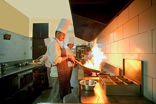 Chef cooking over a flame in the kitchen